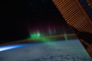 Green and purple auroras shimmy above the orange airglow of Earth's upper atmosphere in this colorful view from the International Space Station. NASA astronaut Chris Cassidy captured this image while the space station was orbiting above the Indian Ocean, between the continents of Australia and Antarctica, on June 7, 2020.