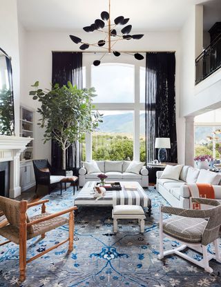 Modern living room with two sofas, black curtains and blue rug
