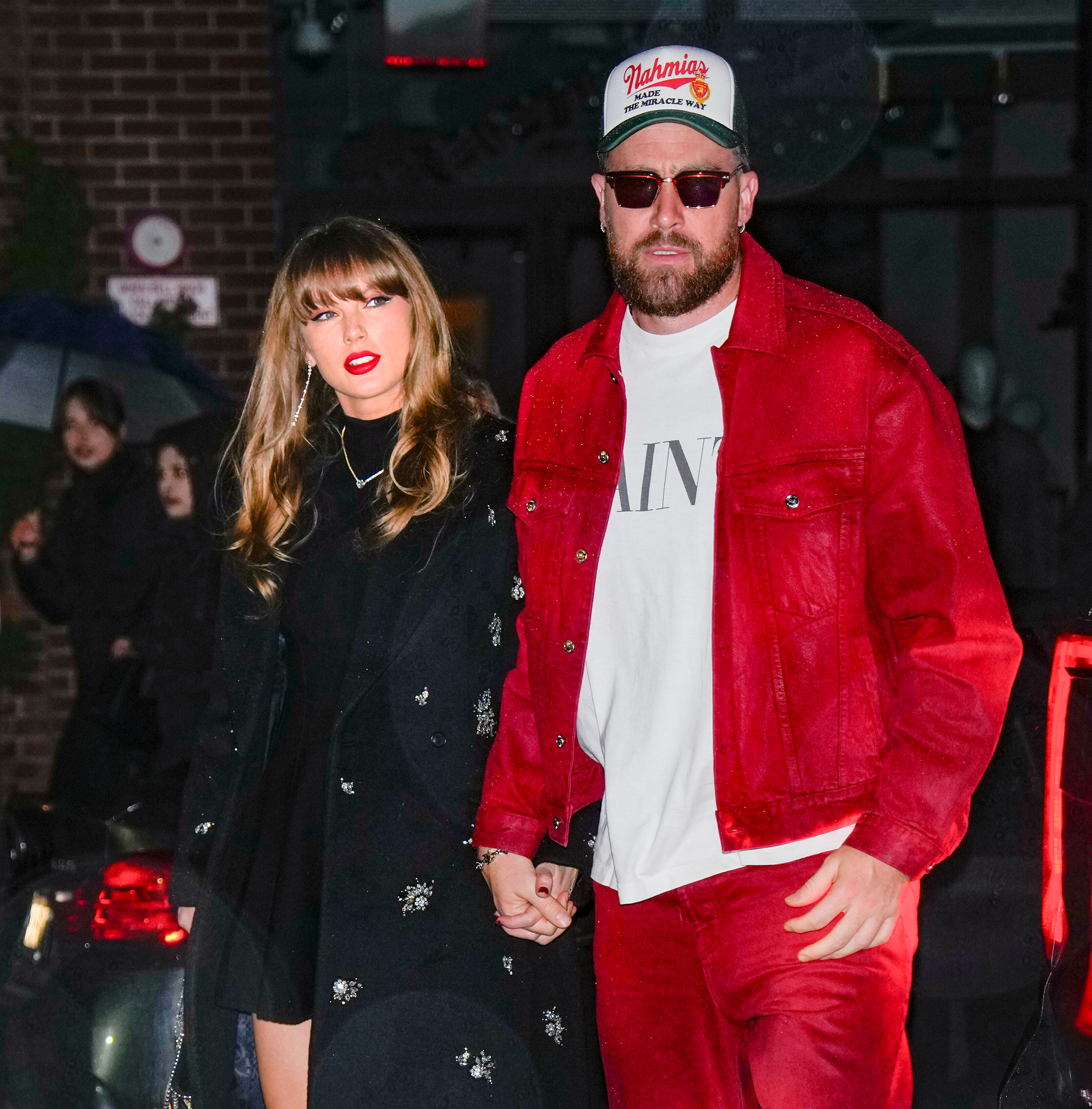 Taylor Swift and Travis Kelce hold hands while Swift wears DeBeers earrings