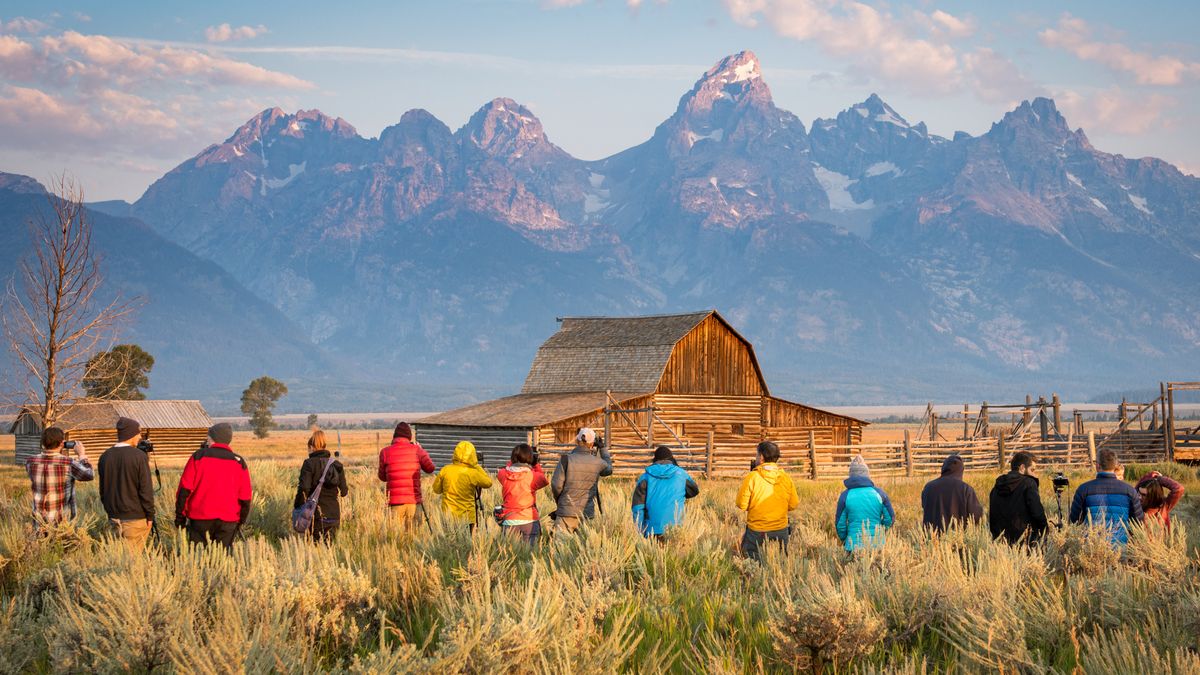 Photographers working in Grand Tetons National Park photographing a barn and mountains