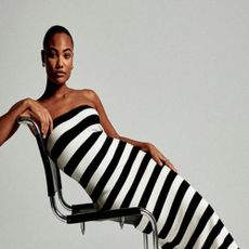 Woman in a black and white striped dress from Abercrombie posing on a chair