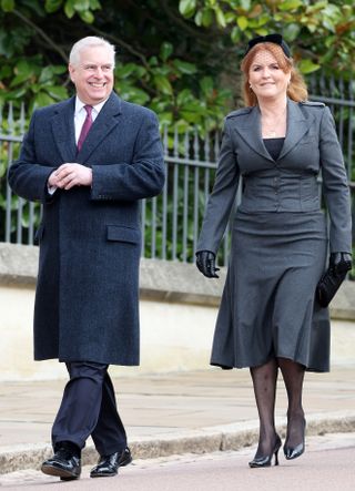 Prince Andrew and Sarah Ferguson walking outside next to each other smiling and wearing dark suits