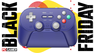 The purple version of the 8BitDo Pro 3 controller sits in its charging dock. Both are seen in the funky Black Friday deal void.