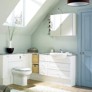 attic bathroom with white walls and cabinets
