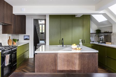 a green and fluted wood kitchen with a square island