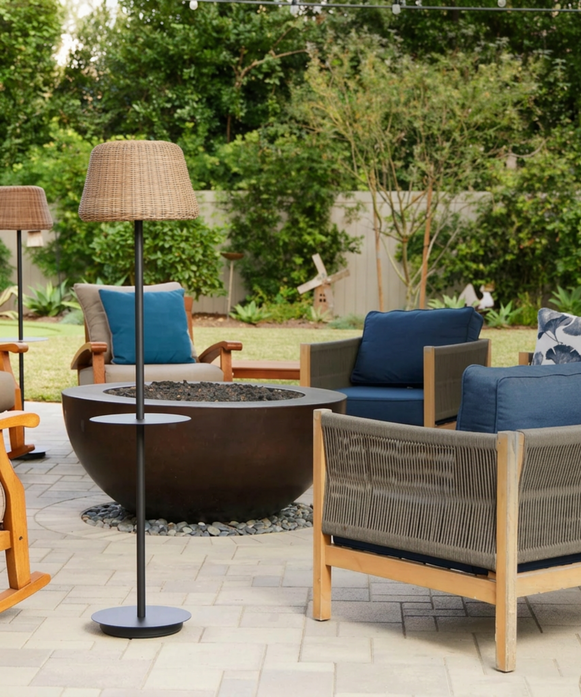 a patio with a fire pit, several lounge chairs, and a floor lamp