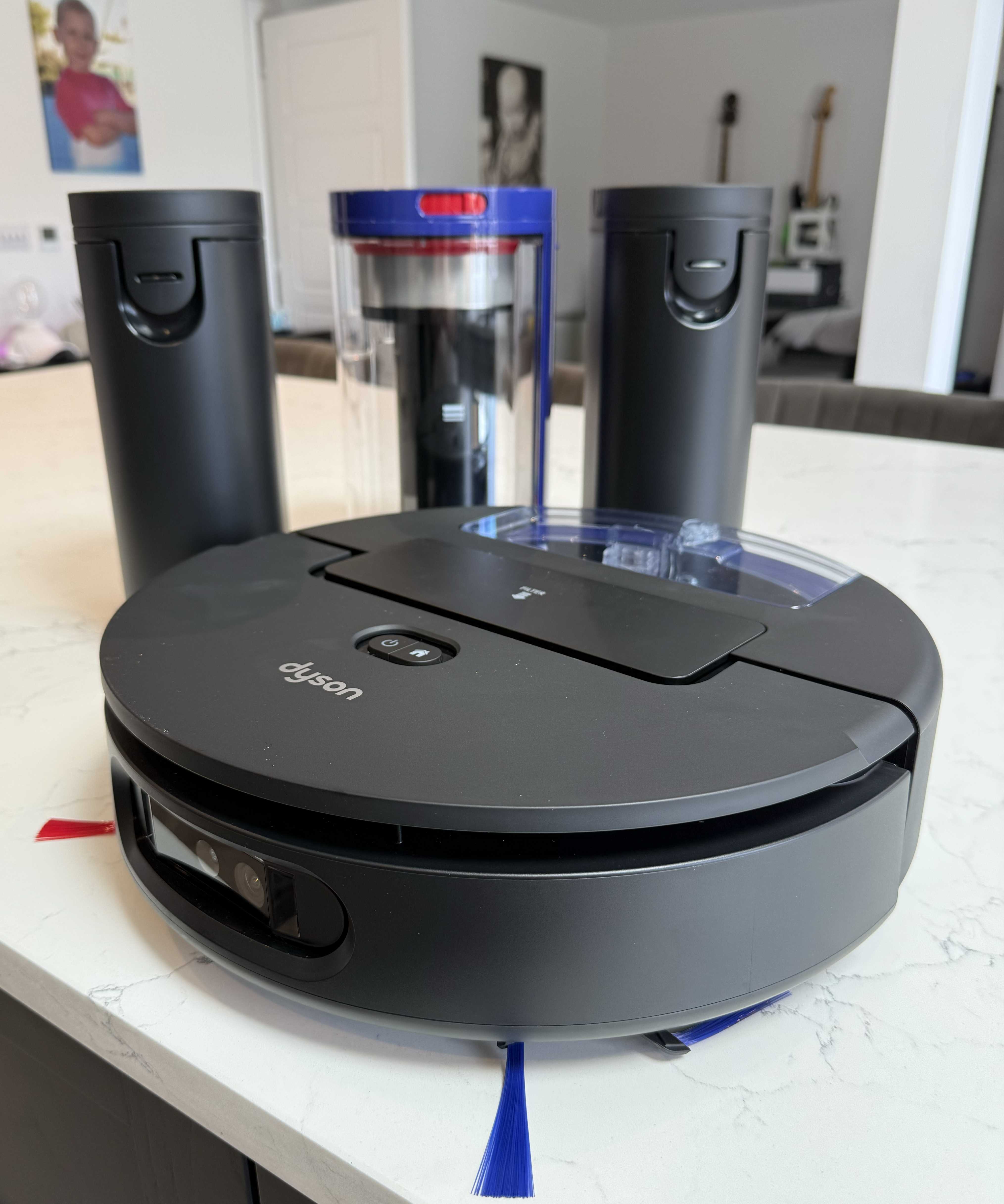 Dyson Spot+Scrub Ai robot vacuum and dock components laid out on a kitchen countertop
