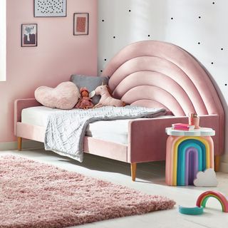 Upholstered pink velvet kids bed with rainbow shaped back