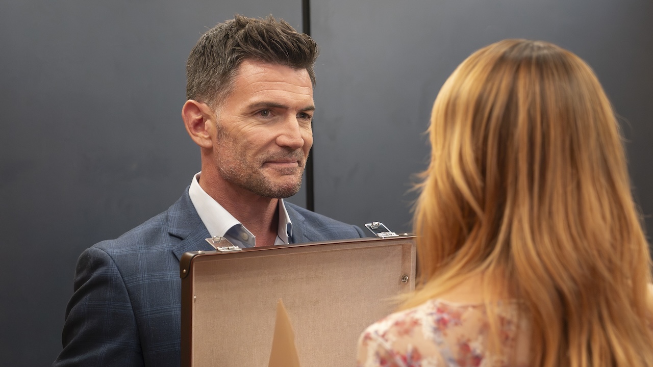 Rhys holding open briefcase to Morgan in High Potential Season 2 winter premiere