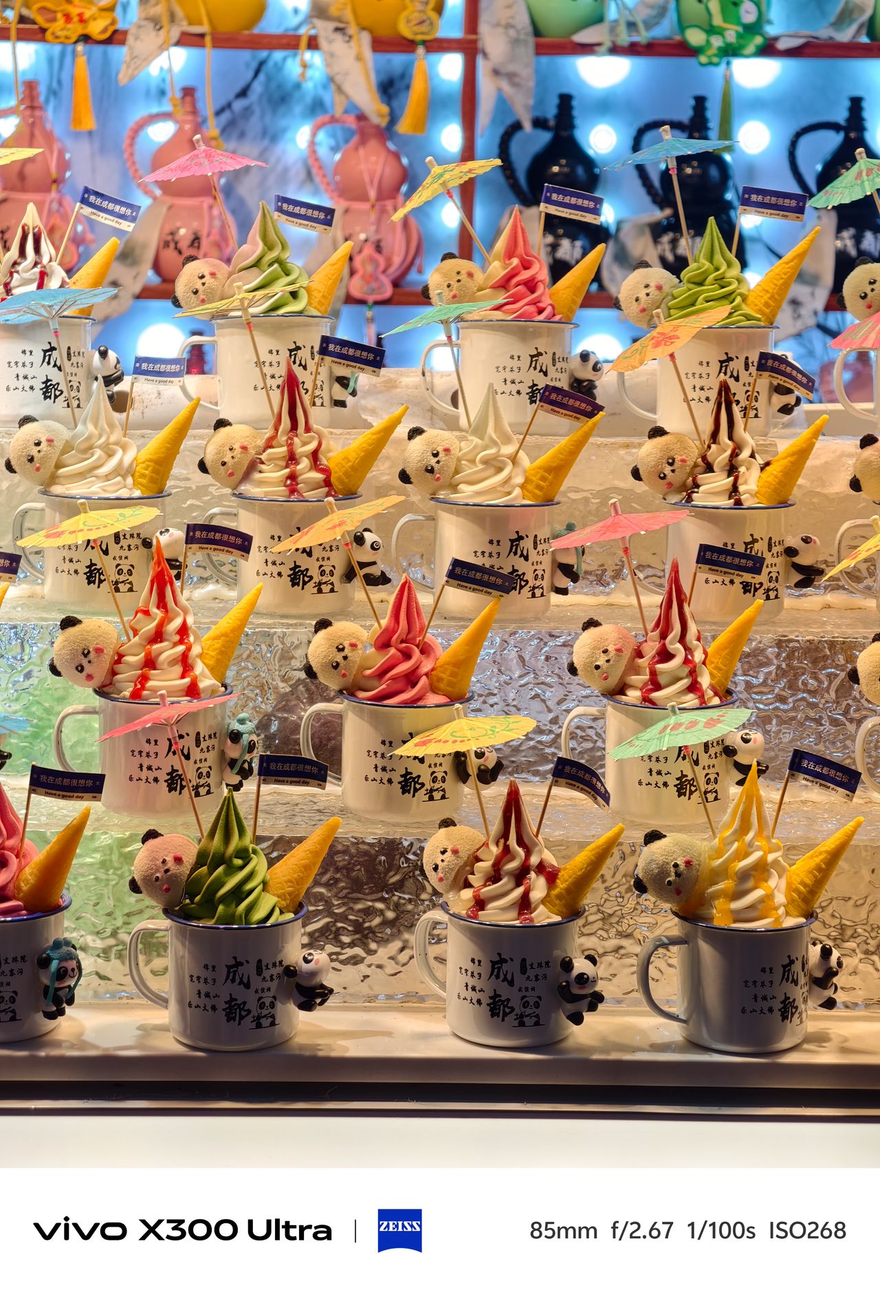 Rows of panda-themed ice cream mugs filled with colorful soft serve, cones, and tiny umbrellas.