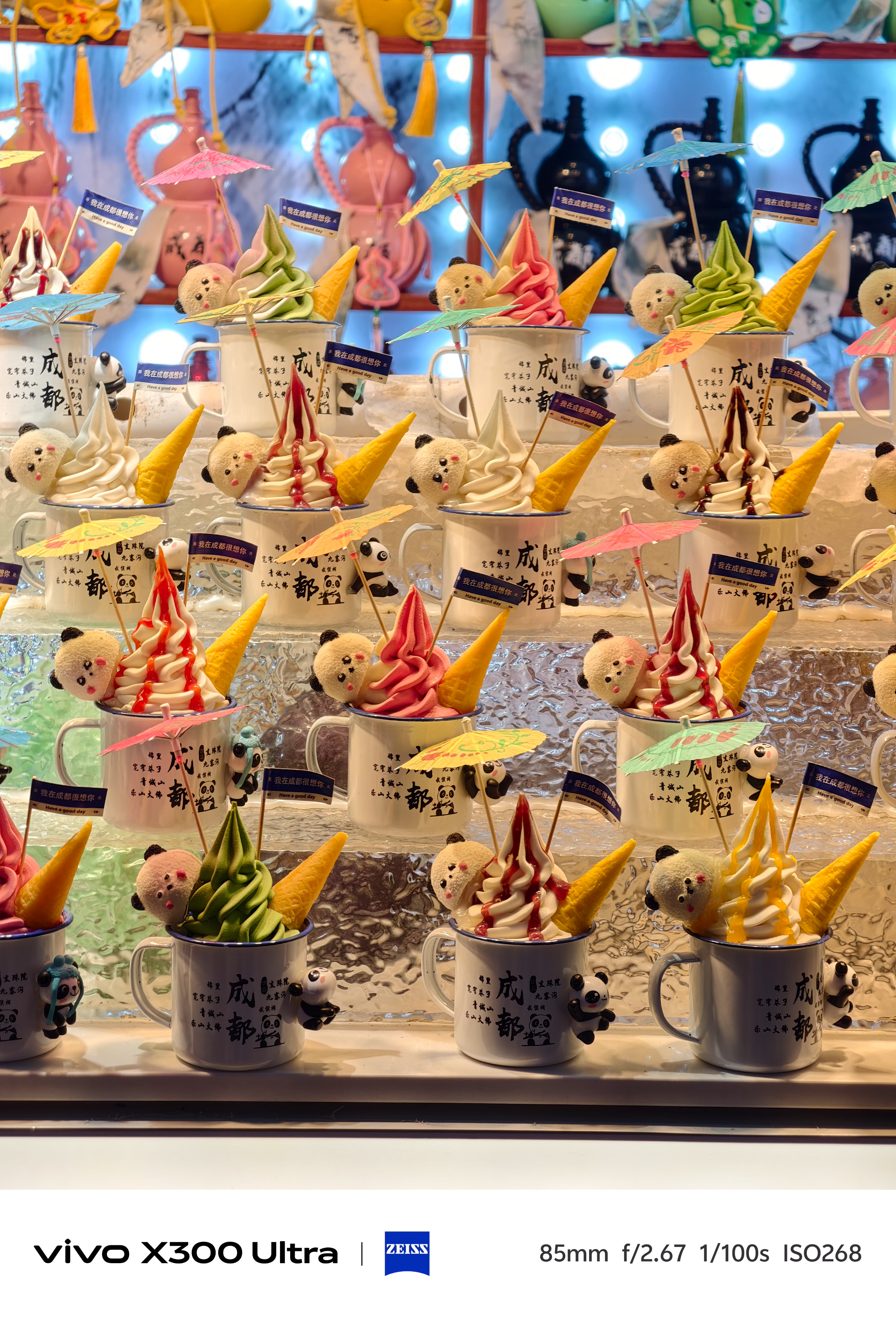 Rows of panda-themed ice cream mugs filled with colorful soft serve, cones, and tiny umbrellas.
