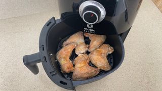 Magic Bullet Air Fryer with tray open, showing nicely browned chicken wings
