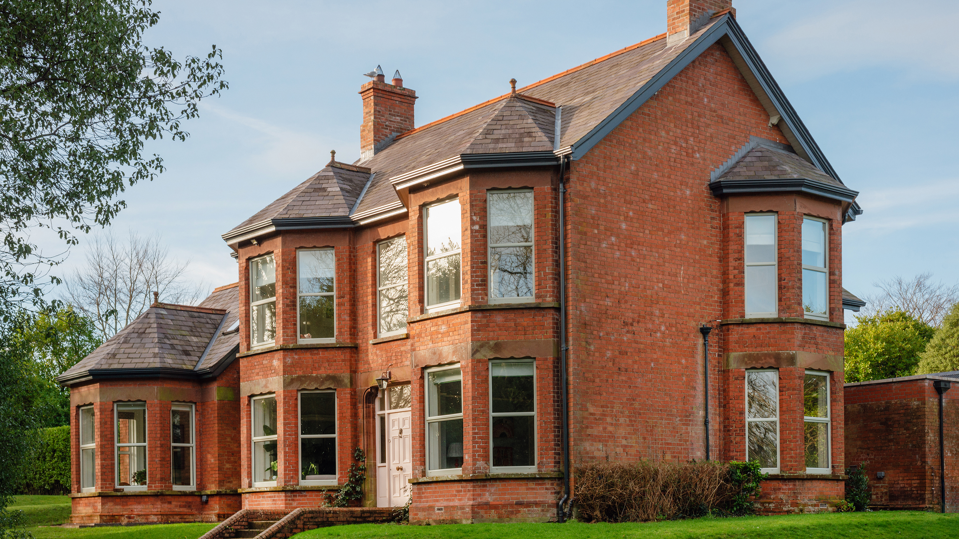exterior of a double fronted Victorian home with double bay windows and side extension