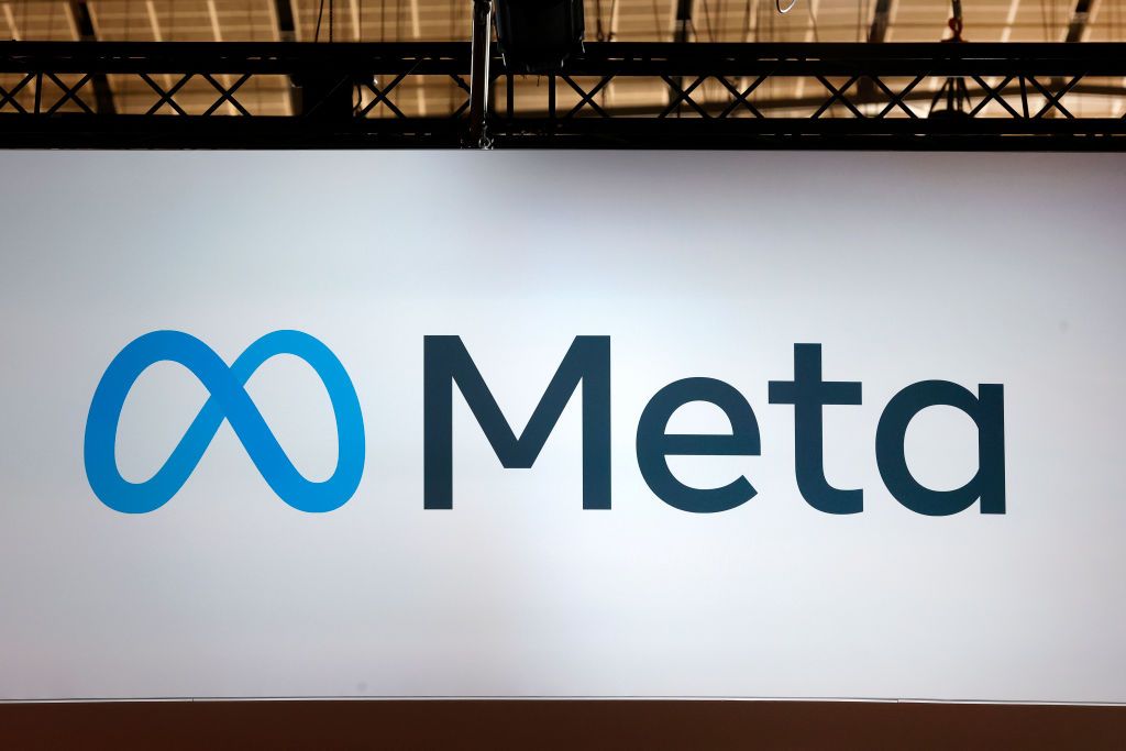 A close up of a large, brightly lit street billboard with the Meta logo displayed