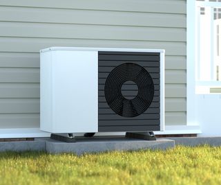 white and black heat pump on concrete plinth outside weatherboard covered wall of home