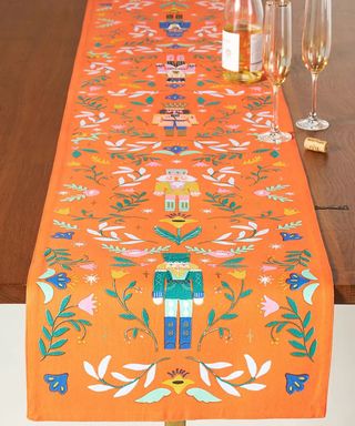 nutcracker table runner on a wood table by anthropologie