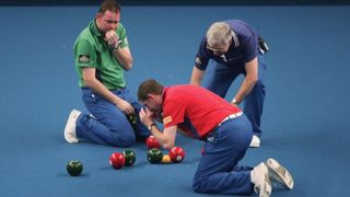 Mark Price of Wales and Paul Forster of Scotland view their bowls during the singles final match at the Potters Holidays World Indoor Bowl Championships