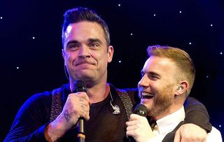 Robbie Williams putting an arm around Gary Barlow