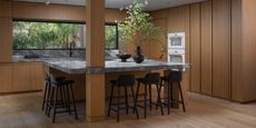 modern timber kitchen with square marble island bench and five bar stools