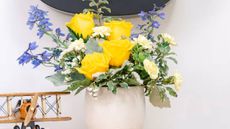 A bouquet from Teleflora with yellow roses, white carnations and purple flowers. 