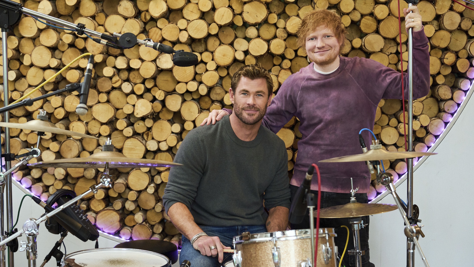 Ed helps Chris learn the drums in Limitless: Live Better Now 