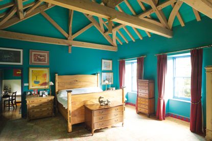 teal bedroom with beams and wooden furniture