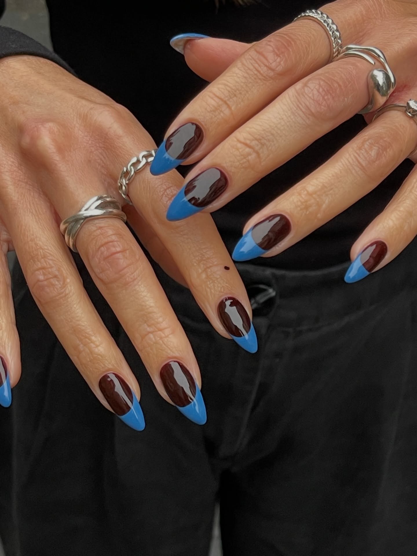 long almond shaped nails with cobalt blue french tips and dark burgundy bases