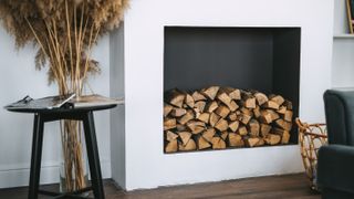 empty fireplace stacked with logs