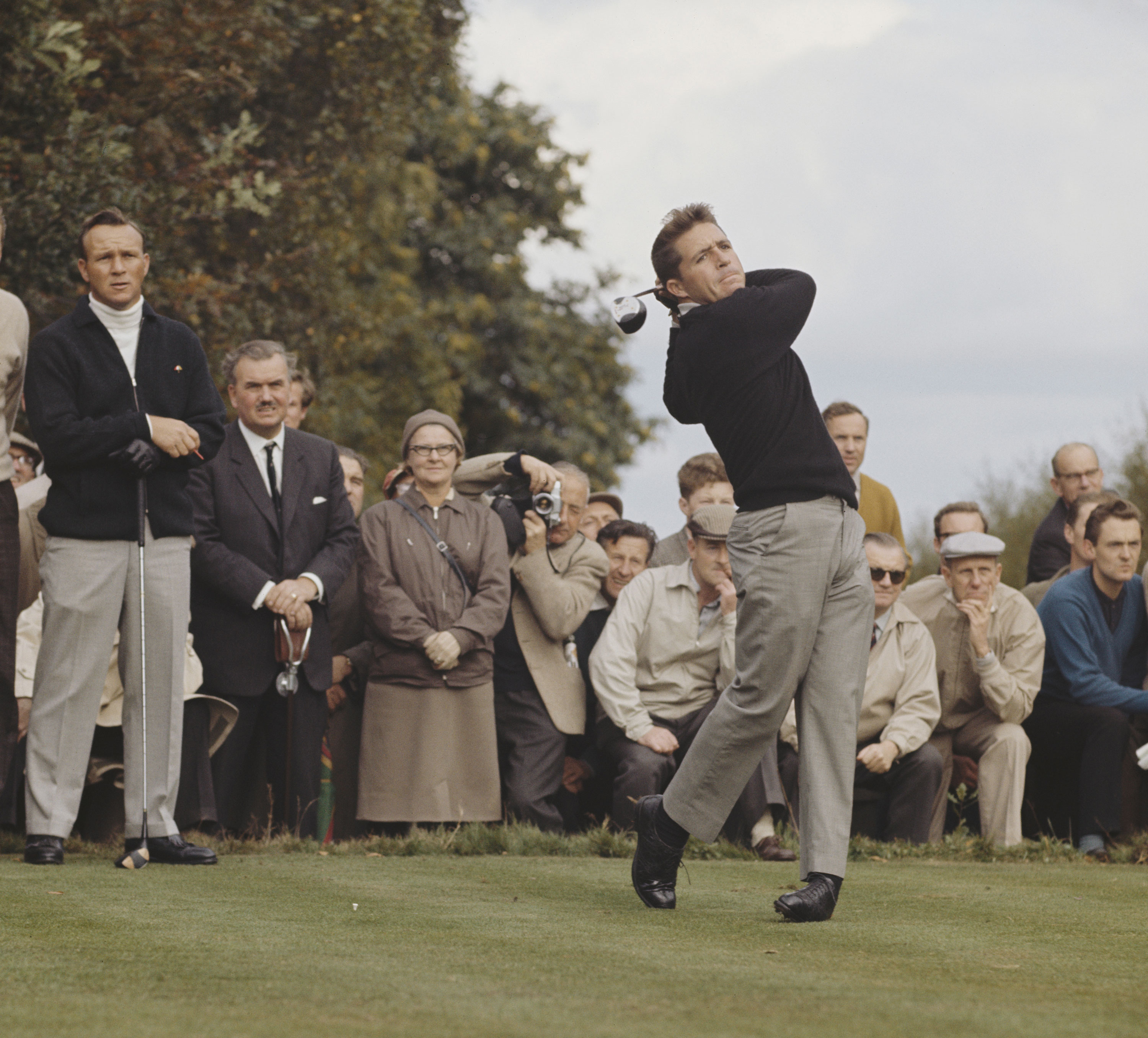 Gary Player driving with Arnold Palmer watching
