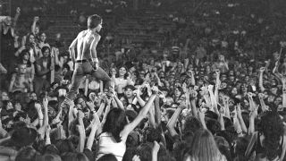 Iggy Pop of the Stooges rides the crowd during a performance at the Cincinnati Pop Festival at Crosley Field, Cincinnati, Ohio, 13th June 1970.