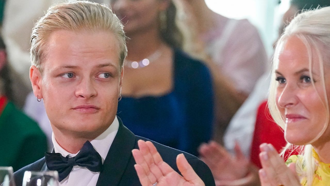 Crown Princess Mette-Marit smiling and clapping as her son Marius Borg Hoiby, wearing a tux, looks at her 