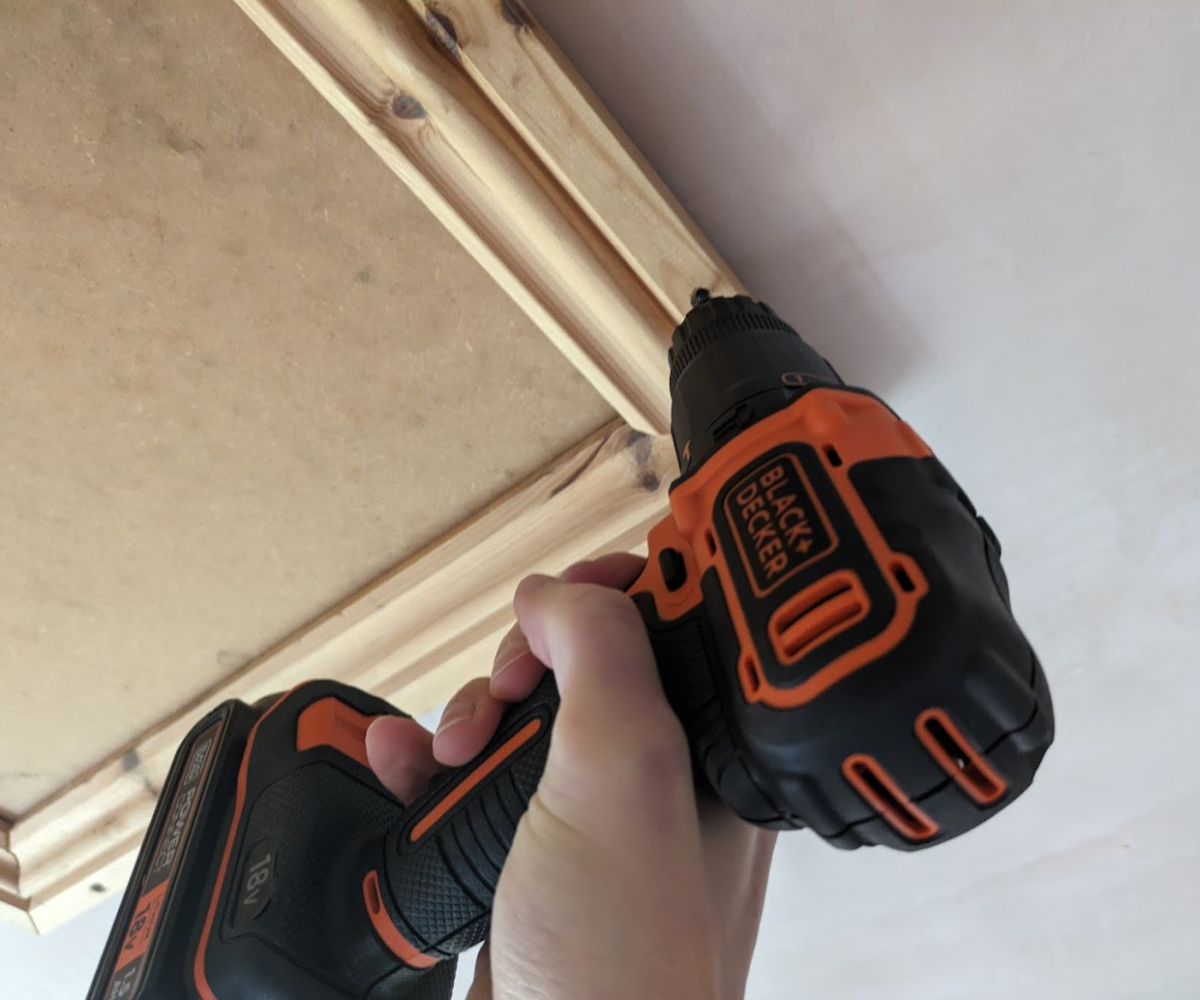 Screwing a loft hatch into place using a combi drill