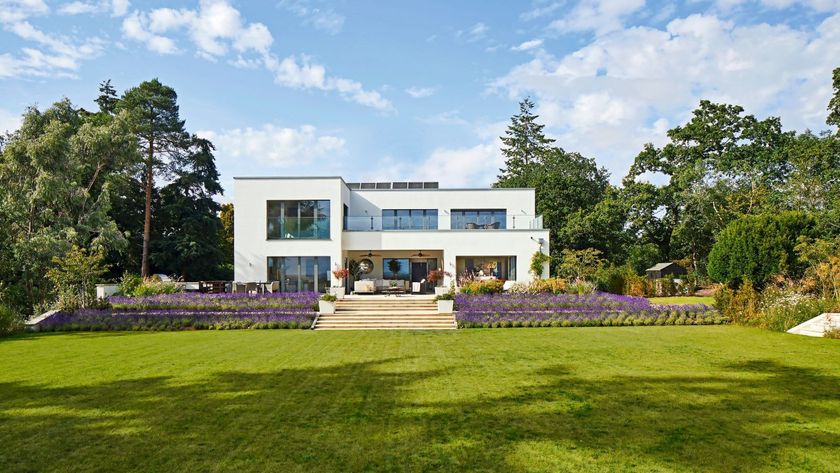 A contemporary home with a white render exterior and a large lawn to the front of the image