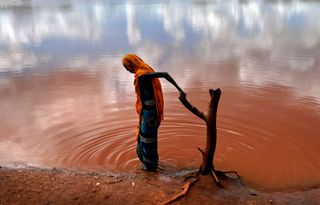 a person by a body of red water