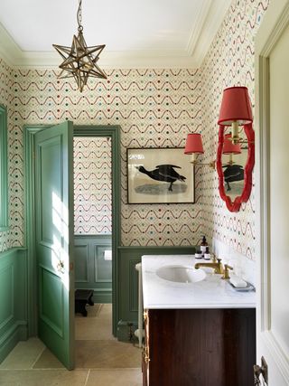 Cloakroom with green panelling and geometric wallpaper