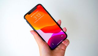 An iPhone 11 Pro held in a hand.