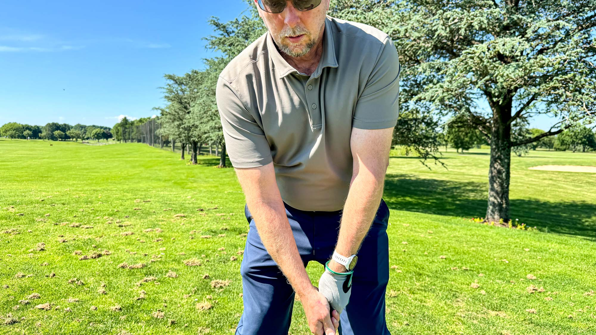 Man wearing the Lululemon ShowZero polo shirt while playing golf on a sunny day