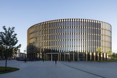 Pictured here, the new Freiburg Town Hall by Ingenhoven Architects. A large round silver vertical strips between many windows.