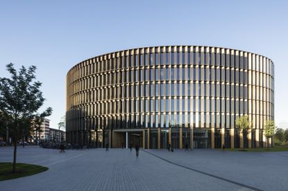 Pictured here, the new Freiburg Town Hall by Ingenhoven Architects. A large round silver vertical strips between many windows.