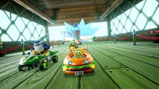 SpongeBob, in a burger car, races through The Krusty Krab with Big the Cat nearby in Sonic Racing: CrossWorlds