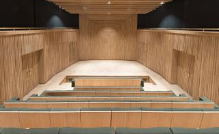 Wood-lined auditorium with grey upholstery