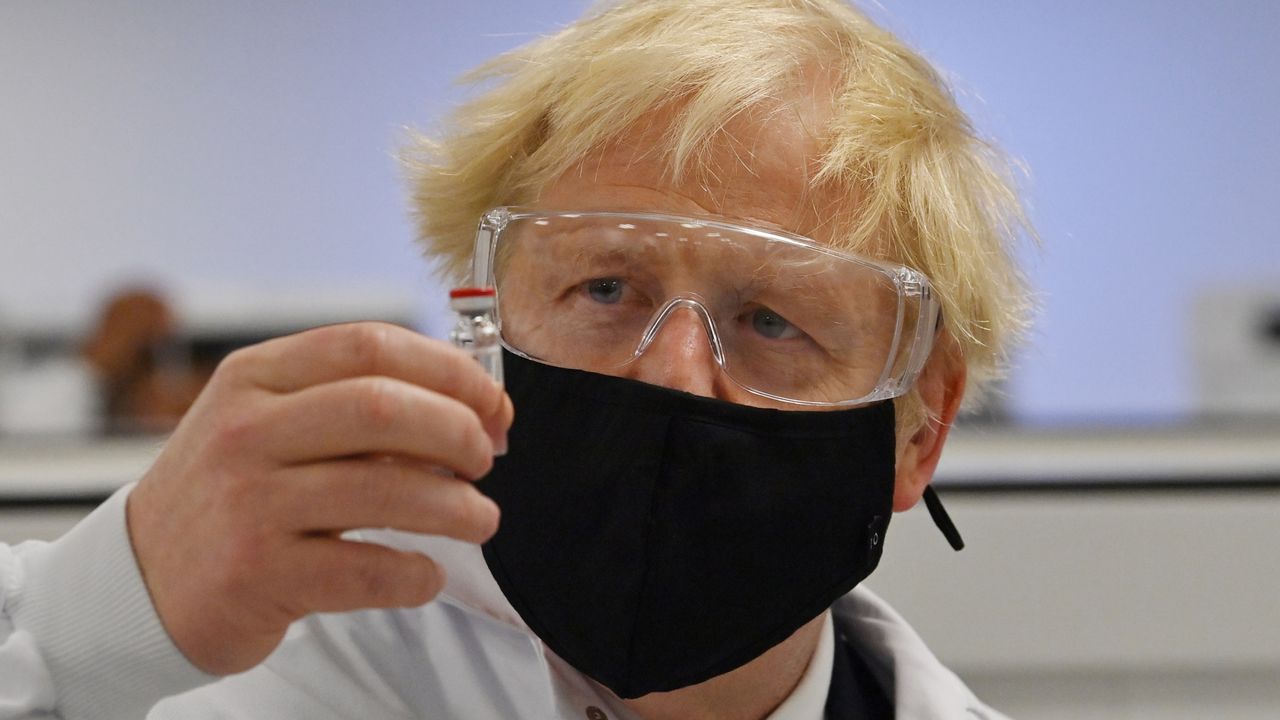 Boris Johnson poses with a vial of the Oxford-AstraZeneca vaccine