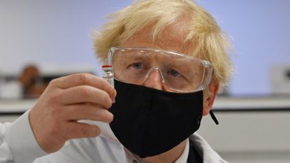 Boris Johnson poses with a vial of the Oxford-AstraZeneca vaccine