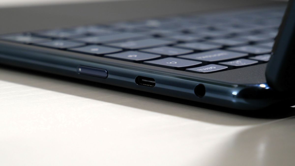 Lenovo Yoga 9i 2-in-1 Aura Edition open on a white desk, highlighting the ports on the right, including one USB Type-C and headphone jack.