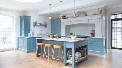 Characterful kitchen diner with Georgian bespoke carpentry in bright blue, kitchen island and range, spacious, light and airy. 
