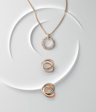 Cartier Trinity gold rings and a pavéd pendant necklace