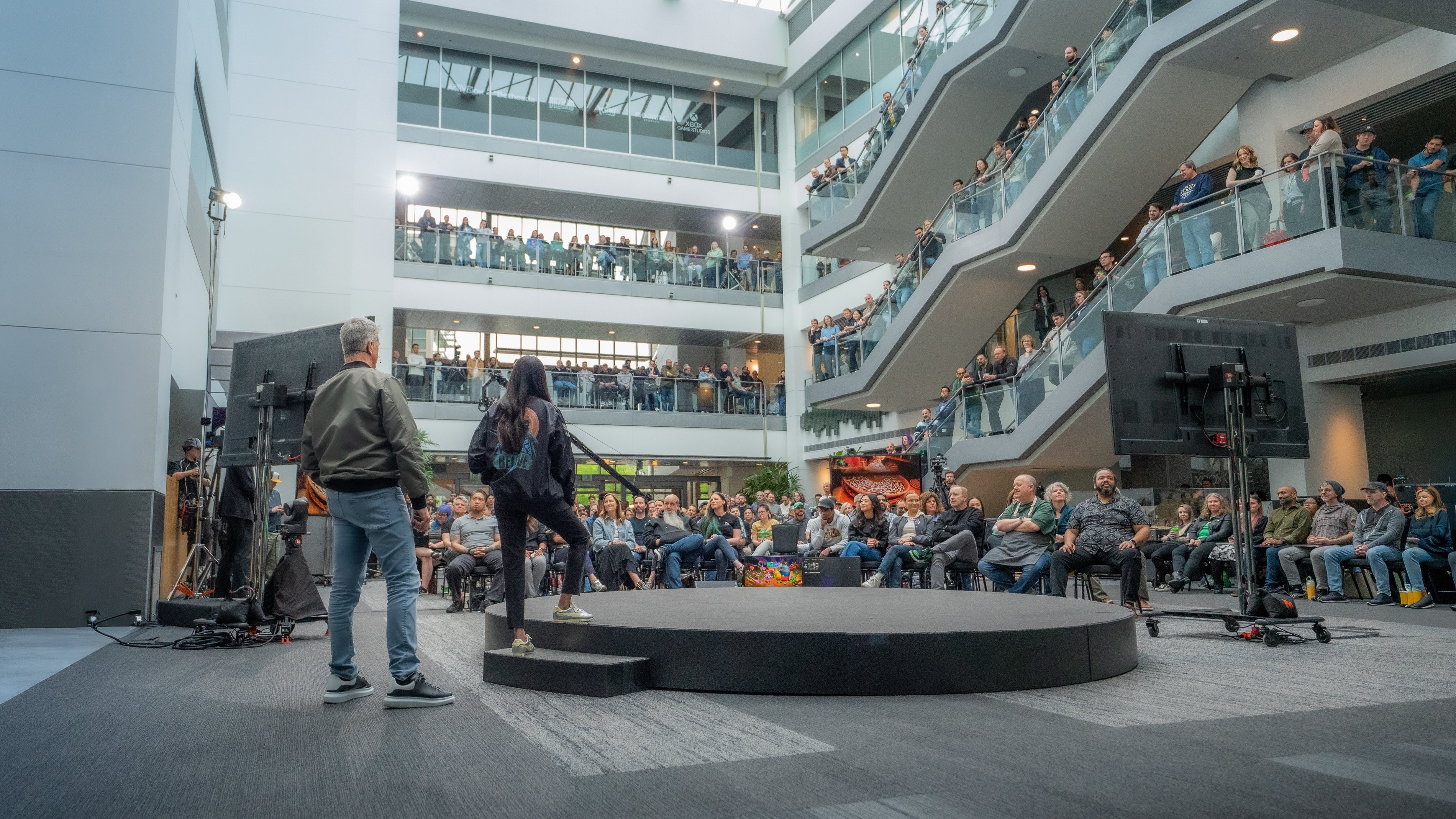A photograph of Xbox CEO Asha Sharma and CCO Matt Booty meeting with Team Xbox.