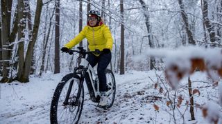 Woman riding e-bike on snowy trail