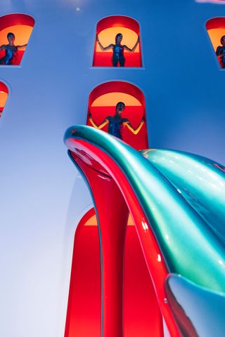 a model ready to head down a slide at a Christian Louboutin miss z presentation in paris