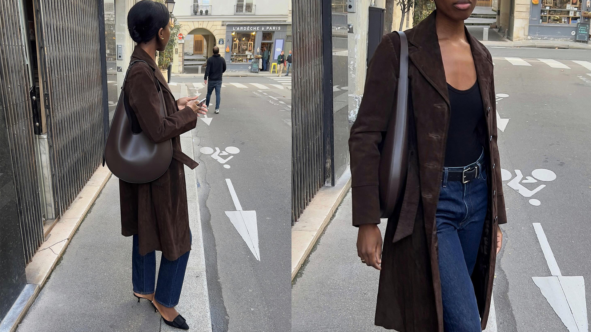sylvie wears brown suede coat, jeans, black top, and deep brown leahter shoulder. bag